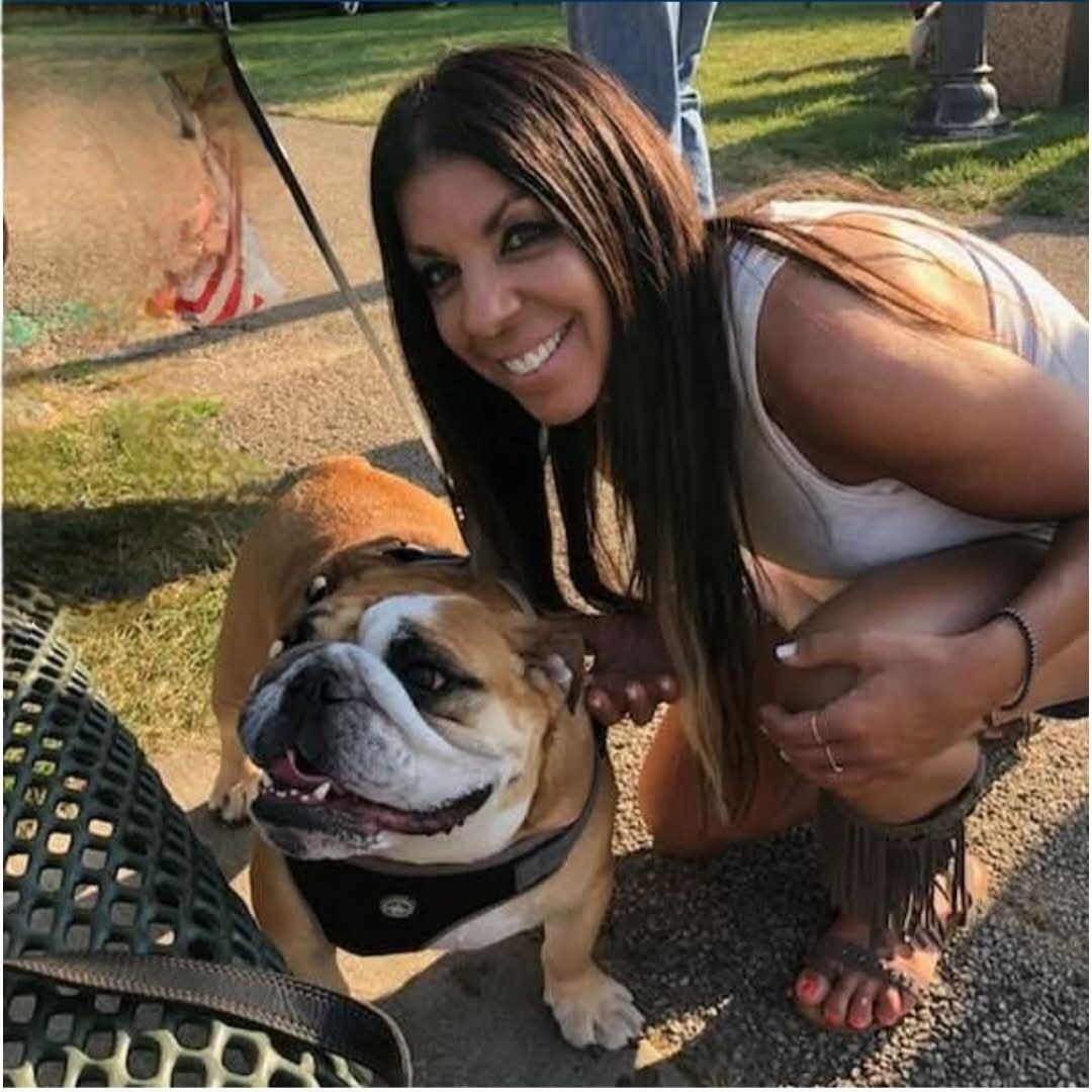 Christie smiling next to a happy bulldog
